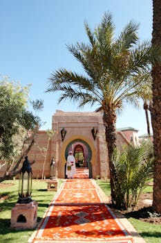 Scenic entrance to a Moroccan villa surrounded by palm trees in Marrakech.