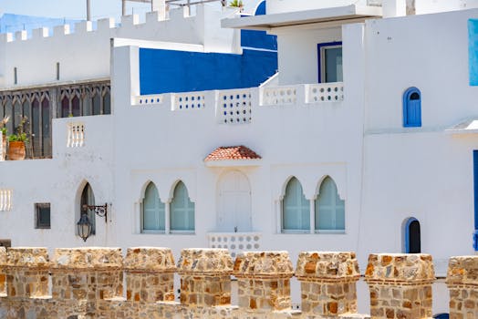 Beautiful white and blue house facade in Asilah, Morocco, radiating summer light and vibrant culture.